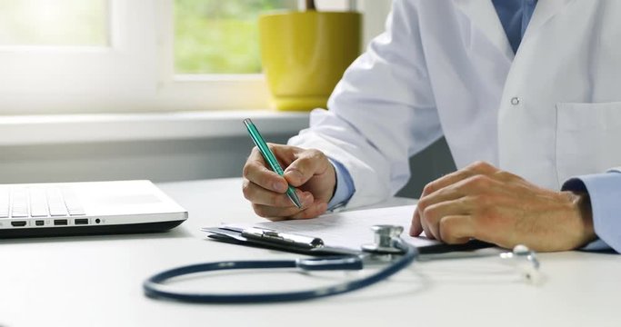 doctor working at desk in clinics office