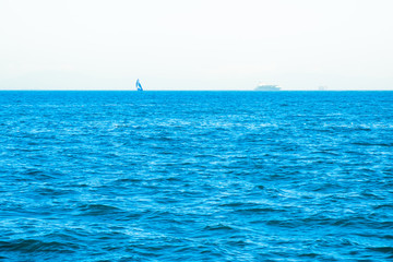 Lonely sailing boat in open sea. Beautiful romantic landscape, seascape. Luxury sports and recreation background. Horizontal image with copy space. 