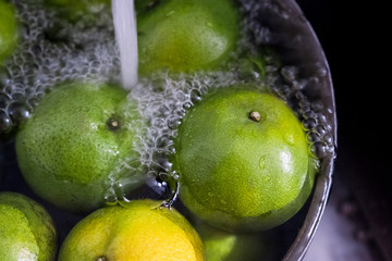 Fototapeta na wymiar green Tangerine,Fruit are put in a kitchen sink for washing.