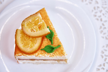 Orange cake on a white plate with a close-up lace.