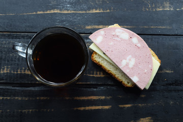 morning breakfast, tea and a sandwich with sausage and cheese