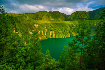 Beautiful sunset volcanic lake among mountains with green lush and trees in Ciete Cidades valley