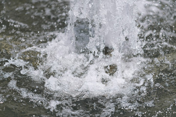 City fountain. Selective focus on water drops.