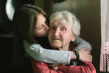 Little girl kissing her grandmother.