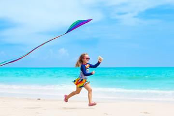 Fototapeta na wymiar Child with kite. Kids play. Family beach vacation.