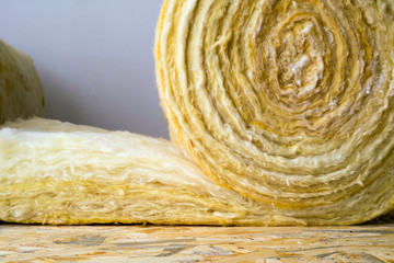 roll of mineral wool lying on the wooden floor