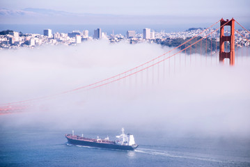 San Francisco Golden Gate bridge on foggy day dramatic evening light cruise ship pass under - Powered by Adobe