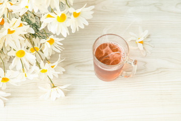 Hot tea cup on the table and notebook with flowers for Good morning or relaxing moments . copy space for text or Use of photo card background and Insert into message .