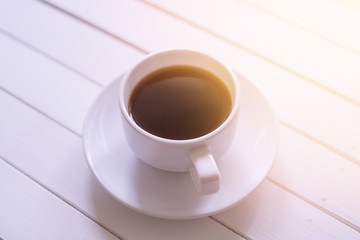 A cup of black coffee on rustic white wooden table with copy space.