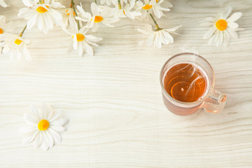 Hot tea cup on the table and notebook with flowers for Good morning or relaxing moments . copy space for text or Use of photo card background and Insert into message .