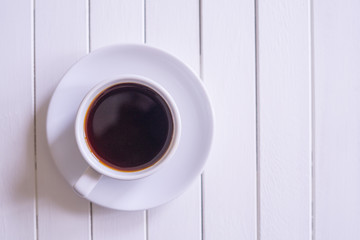 A cup of black coffee on rustic white wooden table with copy space.