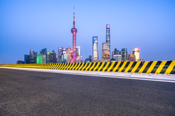 empty asphalt road with city skyline