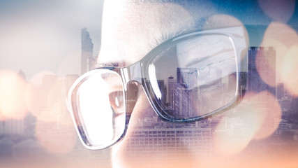 The double exposure image of the businessman's eyes wear a glasses during sunrise overlay with...