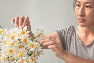 Asian women Florist making fashion modern bouquet of daisy flowers . Freshness in the house.