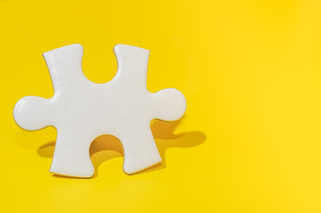 A piece of blank white puzzle on yellow background with copy space.Education and business background concept.