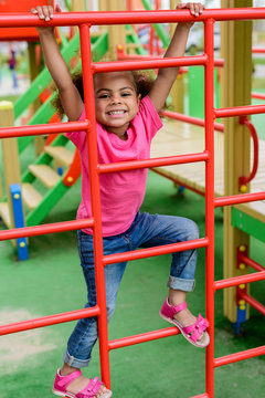 Happy Curly African American Little Child Climbing On Stairs At Playground