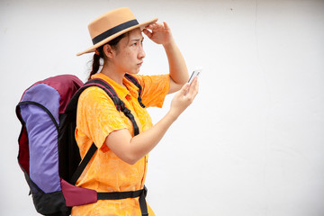 Search for apps and Navigation concept. Asian woman traveling backpacker hiker use smart phone and touching a mobile screen .