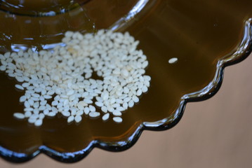 Seeds of sesame kernels in a glass transparent black plate