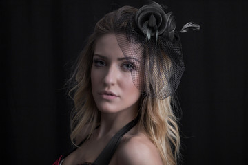 Fototapeta premium Portrait of attractive woman wearing veil and red lingerie posing on black background
