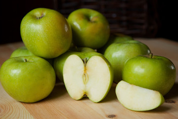 Many green large apples and cut slices