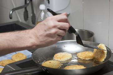 The cook fries potato pancakes