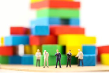 Miniature people : Businessman team standing with colorful wooden,Business concept.