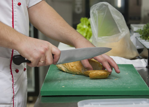 Chef's hands cut bread Close-up