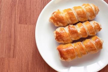 sausage in the dough on a white plate