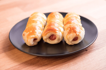 sausage in the dough on a white plate