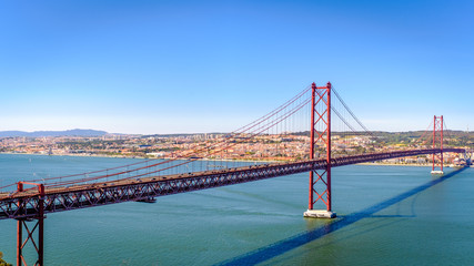 Ponte 25 de Abril. Most famous bridge in Portugal. Lisbon. Red bridge. Sunny day.