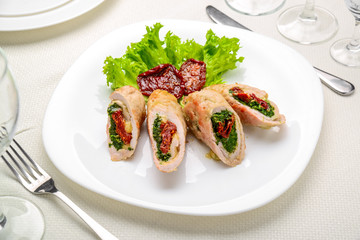 mini chicken rolls with dried tomatoes and spinach. festive dish.