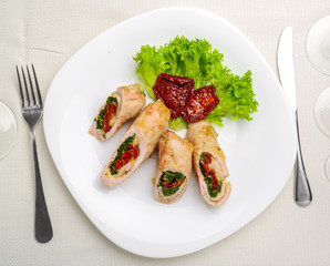 mini chicken rolls with dried tomatoes and spinach. festive dish.