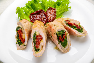 mini chicken rolls with dried tomatoes and spinach. festive dish.