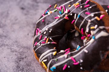 Donut with sprinkles on dark table, closeup