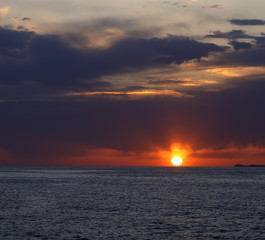 Naklejka na ściany i meble Bright colorful sunset on sea with beautiful clouds