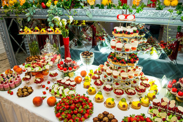 Delicious sweets on candy buffet. Lot of colorful desserts