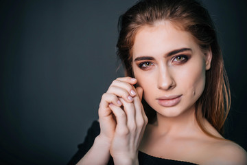 beauty portrait. Studio portrait of a beautiful girl on a gray background. Good make-up. Face close-up