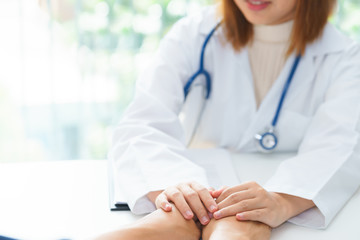 Female doctor holding patient hands for cheerful