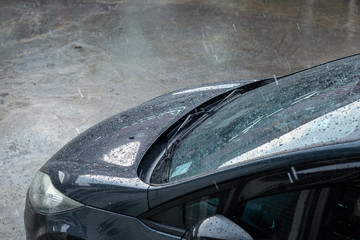 Rain dropping on deep blue car after car wash done.