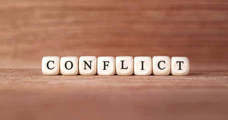 Word CONFLICT made with wood building blocks