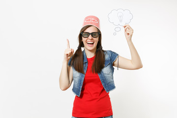 Smiling woman in 3d glasses with bucket for popcorn on head watching movie film holding say cloud with lightbulb, idea and pointing finger up isolated on white background. Emotions in cinema concept.