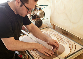 Marking and gluing of footer to the back deck of classical guitar. Production of classical guitar.