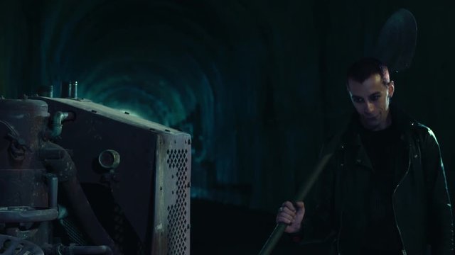 Psychopathic maniac in abandoned place hits with a shovel