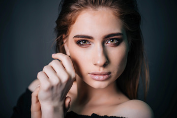 Fototapeta premium beauty portrait. Studio portrait of a beautiful girl on a gray background. Good make-up. Face close-up