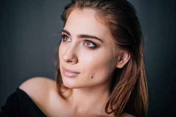 Obraz premium beauty portrait. Studio portrait of a beautiful girl on a gray background. Good make-up. Face close-up