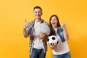 Young win couple, woman man, football fans holding bundle of dollars, cash money, soccer ball,...