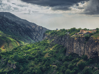 Fototapeta na wymiar aerial view of beautiful mountains landscape with building over cliff on cloudy day, Armenia