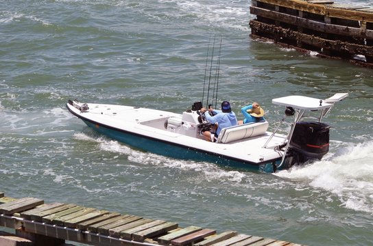 Man and a woman enjoying a week-end outing pn the Florida Intra-coastal Waterway in a sleek sport fishing boat powered by a single outboard engine.
