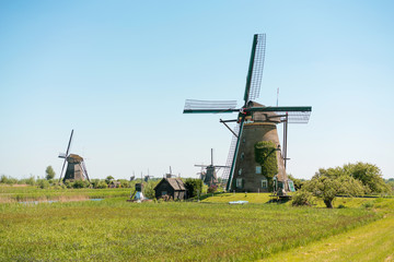 Sunny day at Kinderdijk, Netherlands. Traditional dutch windmills near water cana