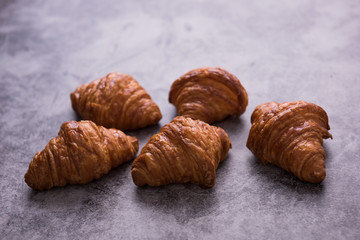 Fresh croissant on a dark table.